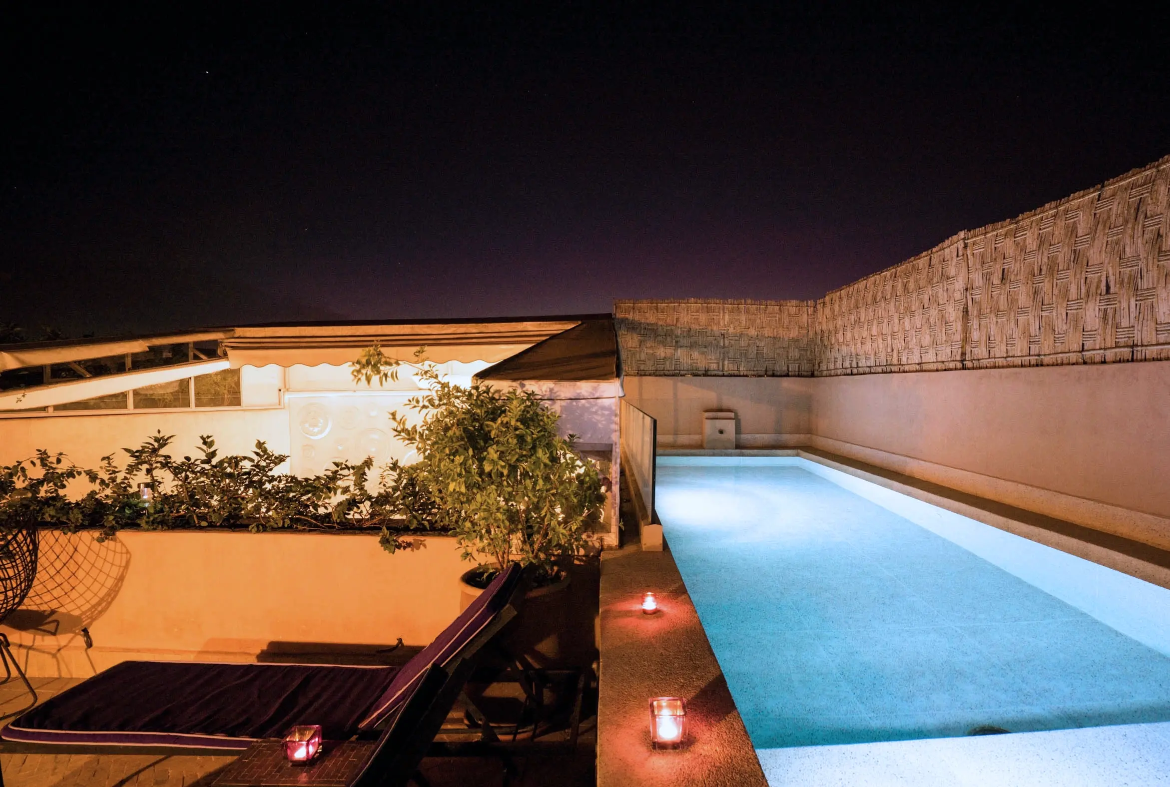 The swimming pool at night, with the lights on.